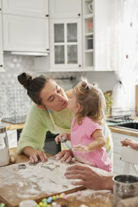 Mother and daughter preparing food in kitchen at home