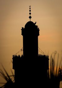 Low angle view of silhouette building against sky during sunset