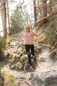 Full length of woman standing in forest