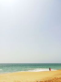 Man on beach against clear sky