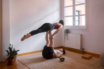 Women doing acroyoga at home