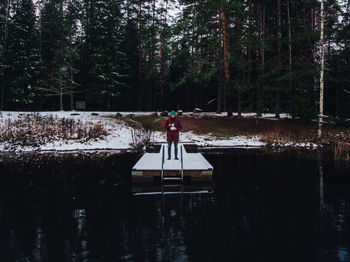 Man standing by lake in forest