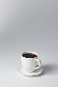 Close-up of coffee cup on table against white background