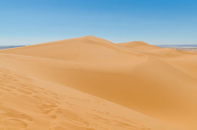 Scenic view of desert against clear blue sky