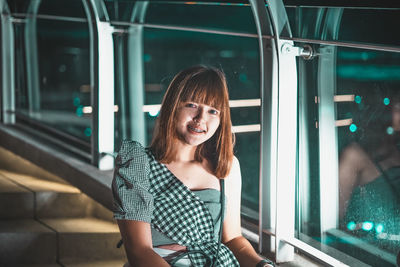 Portrait of smiling woman standing by train