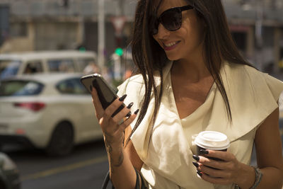 Woman looking at mobile phone in city