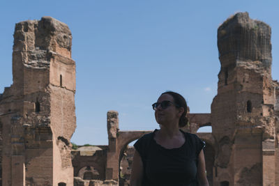 Man looking at old ruin building against sky