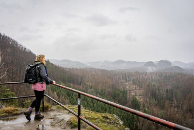 Rear view of woman walking on mountain against sky