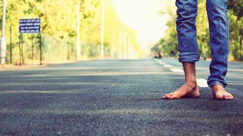 Low section of man walking on street