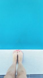 Low section of woman in swimming pool against sea