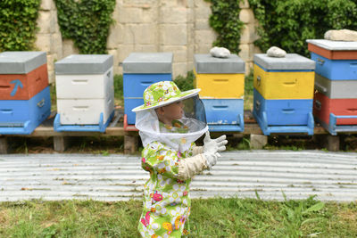 Beekeeper child in apiary in a protective suit