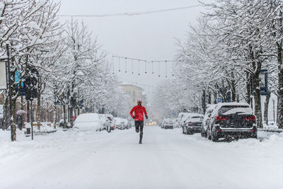 Rear view of person on snow covered city