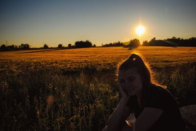 Portrait of woman on field against sky during sunset