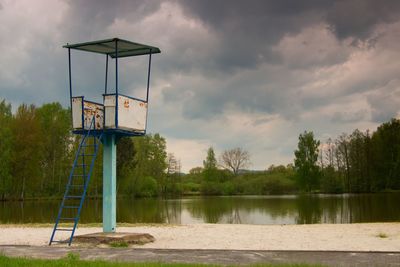 An old white and rusty metal lifeguard tower with chair on a beach