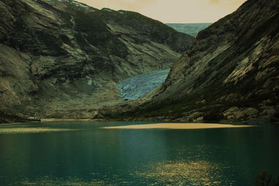 Scenic view of lake by mountains against sky