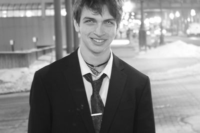 Portrait of teenage boy with spooky eyes standing on street at night