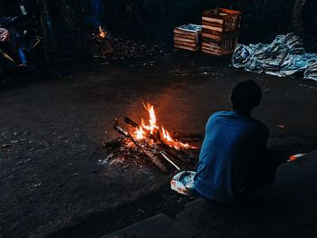 Rear view of people sitting on fire at night