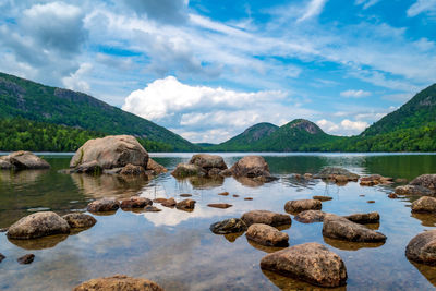 Rocks in lake against sky