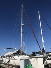 Sailboats in marina against clear sky
