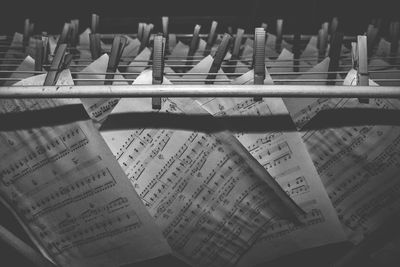 Close-up of music sheets hanging on metal rods