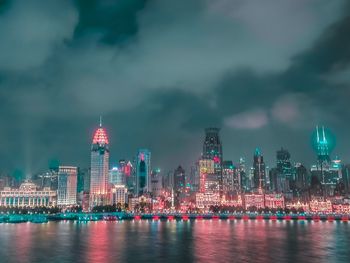 Illuminated buildings in city against sky