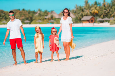 Cheerful family standing on beach