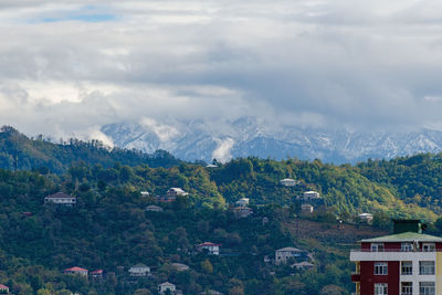 Scenic view of townscape and mountains against sky