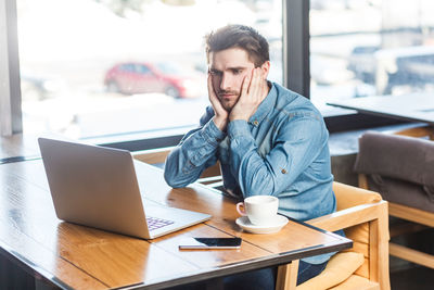 Businesswoman using laptop while sitting on table