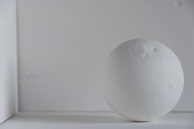 Close-up of bread on table against white wall