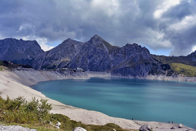 Scenic view of lake by mountains against sky