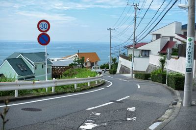 Empty road with buildings in background