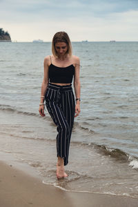 Rear view of woman standing at beach