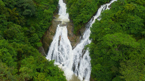 Waterfall in the mountains among the jungle. diyagalla ella falls, sri lanka.