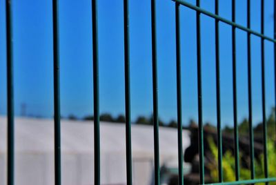 Full frame shot of metal fence against blue sky