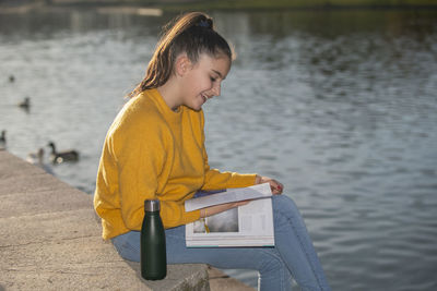 Woman sitting by lake