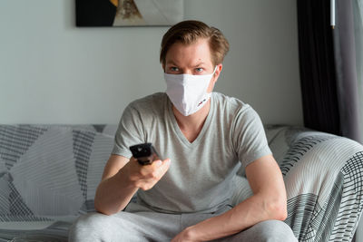 Portrait of man sitting on sofa at home