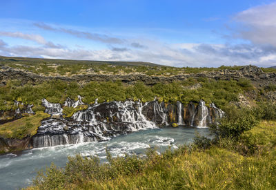 Scenic view of waterfall against sky