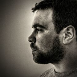 Close-up of serious man looking away against wall