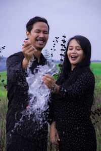 Portrait of smiling young couple standing outdoors