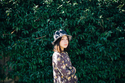 Portrait of woman standing against plants