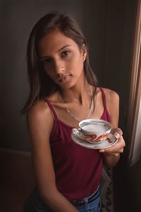 Portrait of beautiful young woman standing at home