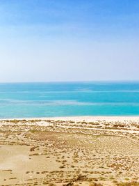 Scenic view of beach against clear blue sky