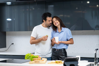 Young man and woman standing in kitchen