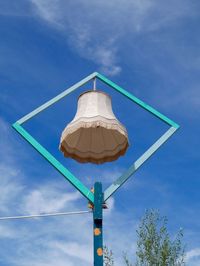 Low angle view of lamp hanging against blue sky