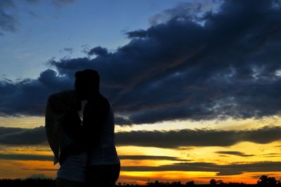 Silhouette man standing against orange sky