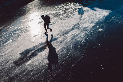 High angle view of silhouette man by sea