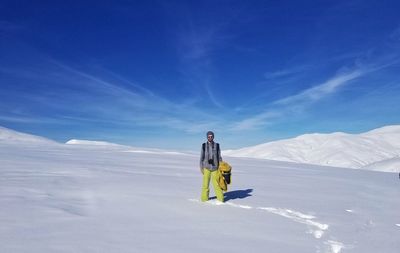 Portrait of man standing on snow covered land against sky