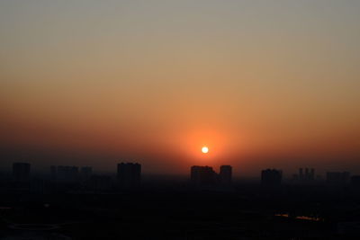 Silhouette buildings against sky during sunset