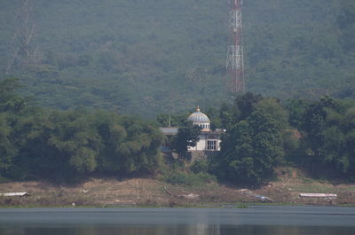 Scenic view of lake by building against trees