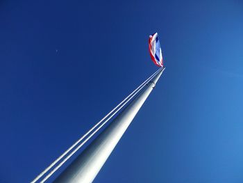 Low angle view of flag against clear blue sky